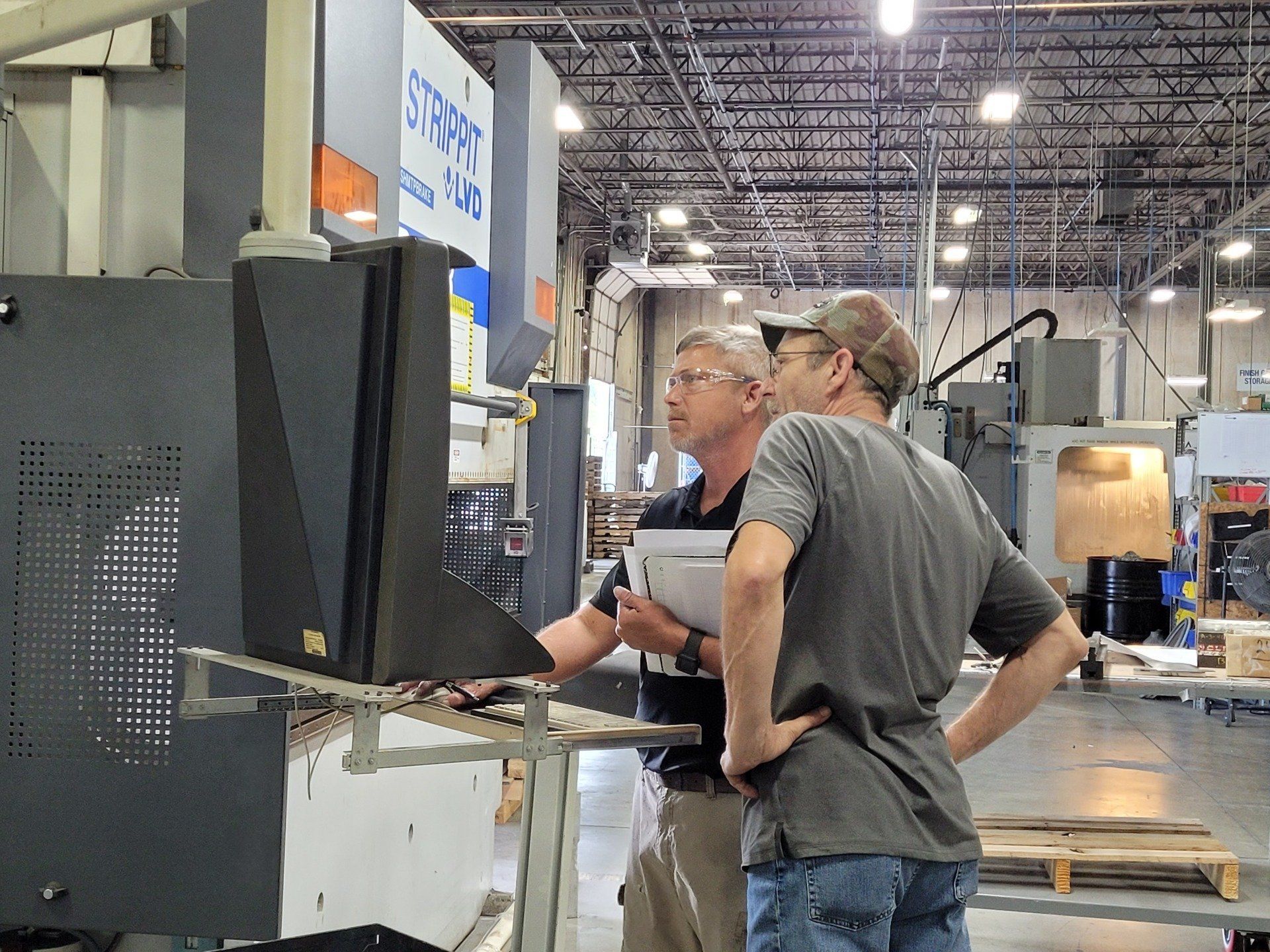 Skilcraft personnel configuring the robotic bend cell